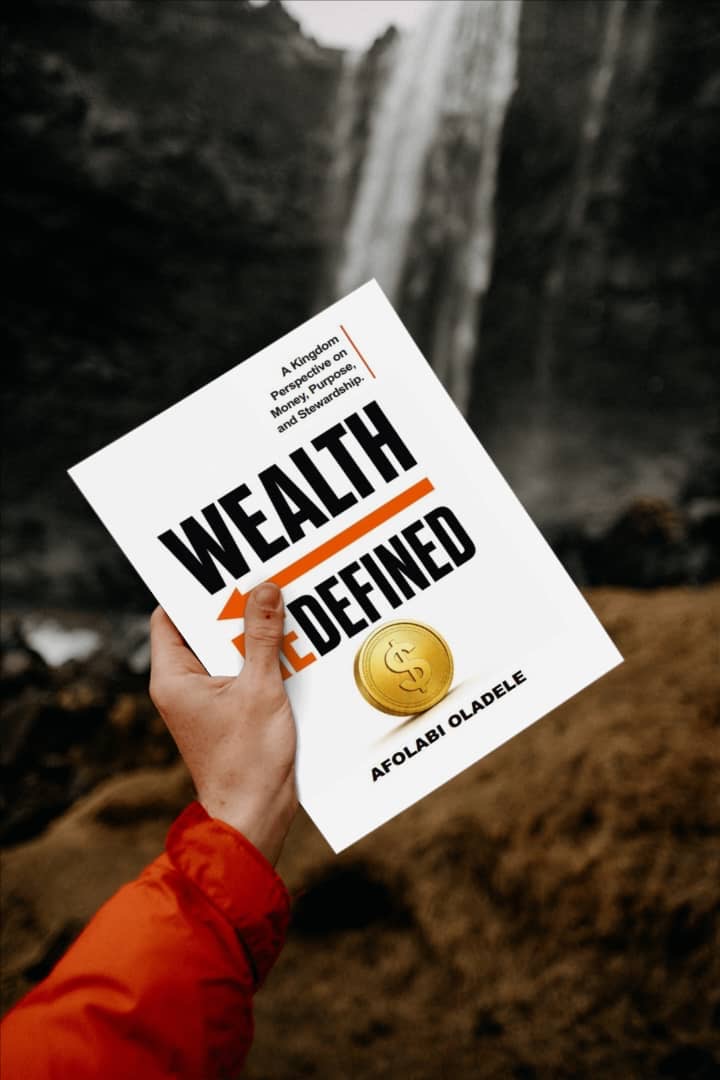 Wealth Redefined held up before a waterfall